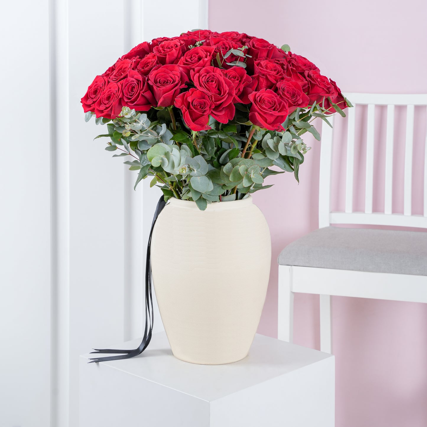 50 red roses in vase arranged with green foliage in a cream ceramic vase from Bloom Marbella