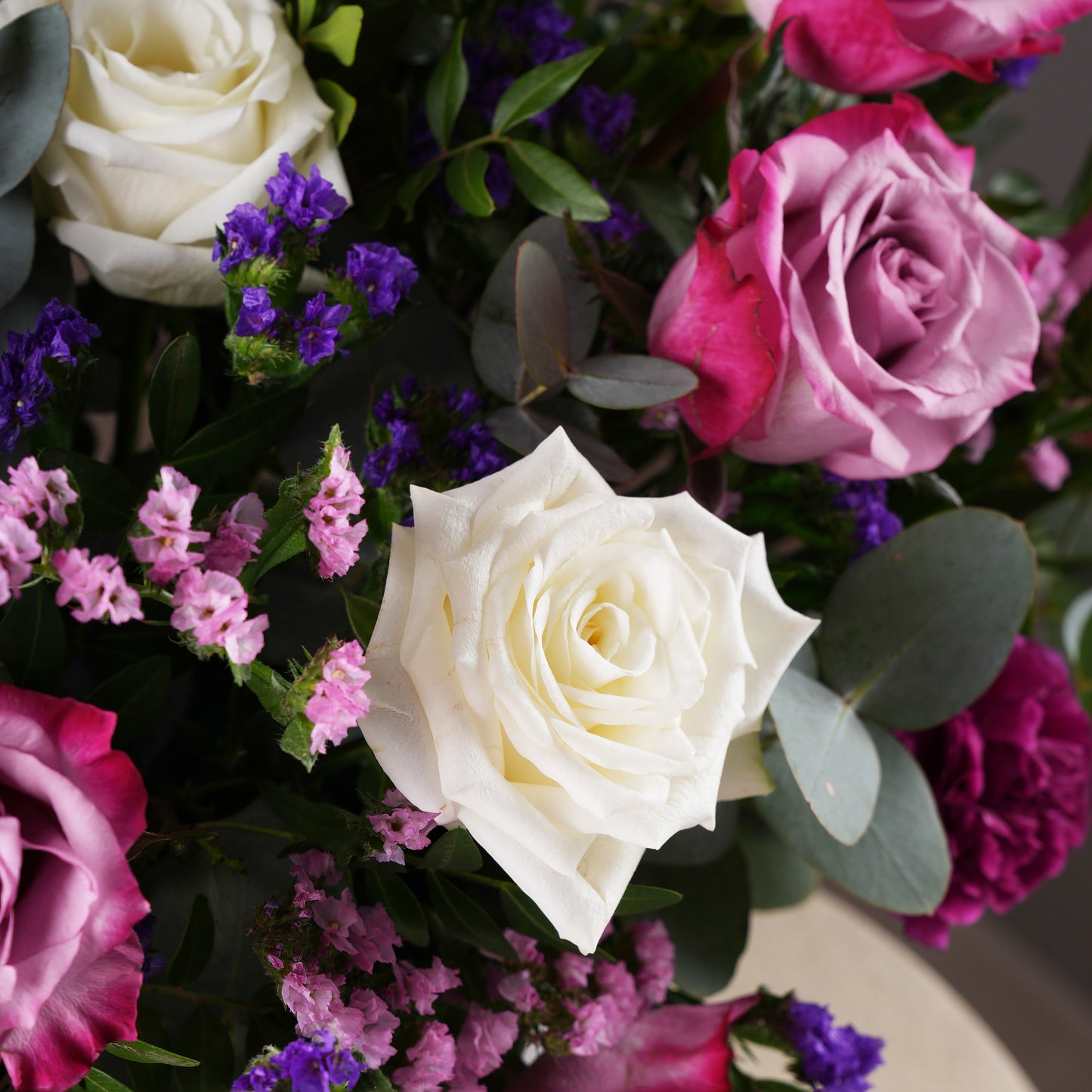 Close-up of lavender hatbox flowers Marbella featuring white and pink roses with purple and pink filler flowers