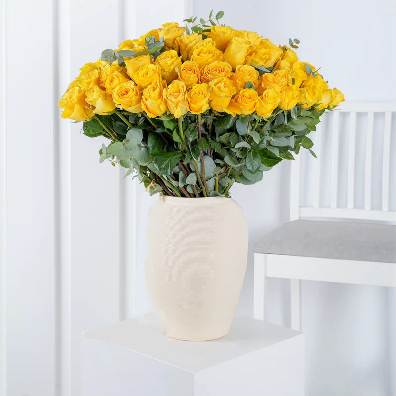 100 yellow roses delivery Costa del Sol Bloom Marbella in a white vase on a small white table