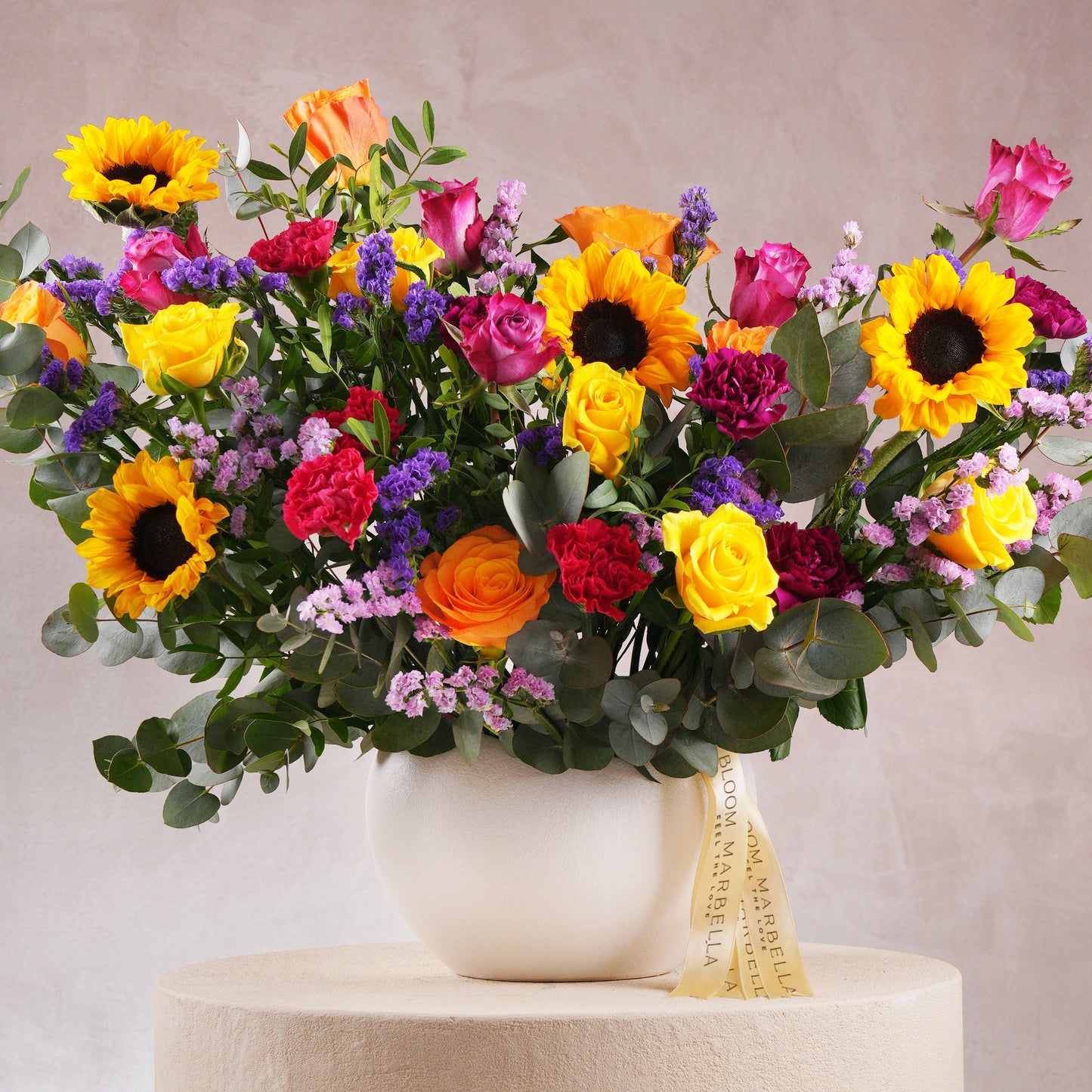 Vibrant floral arrangement Costa del Sol Marbella Bloom Marbella with sunflowers, roses, and mixed flowers in white vase