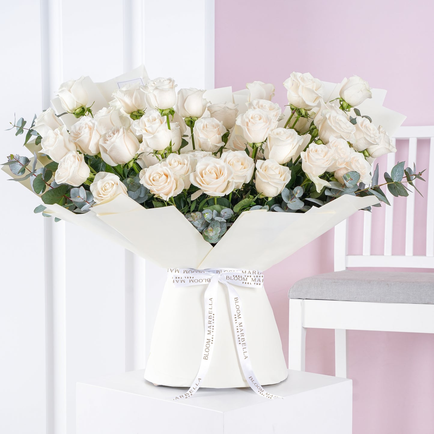 50 white roses bouquet arranged with eucalyptus leaves wrapped in white paper by Bloom Marbella
