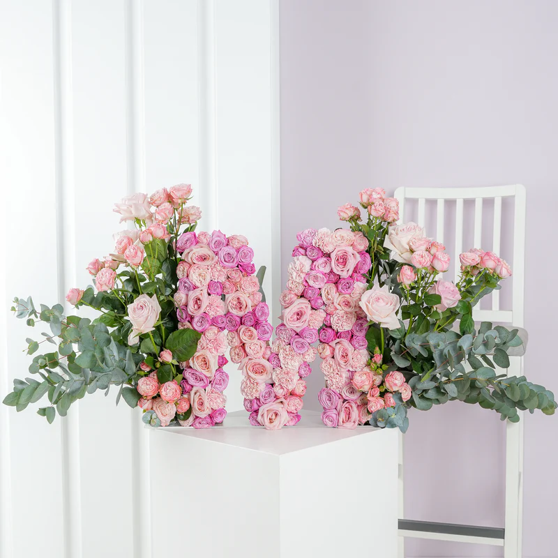Luxury floral letter arrangement shaped as the letter M with pink roses and green foliage