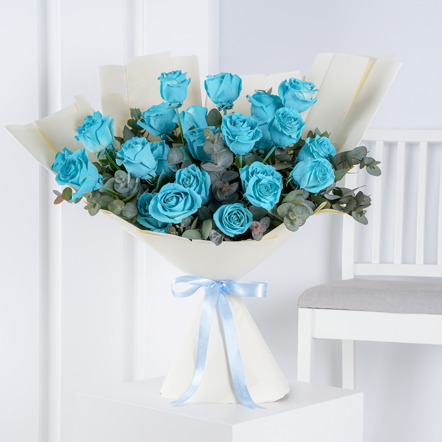 Tiffany blue roses Marbella bouquet wrapped in white paper with eucalyptus greenery and blue ribbon