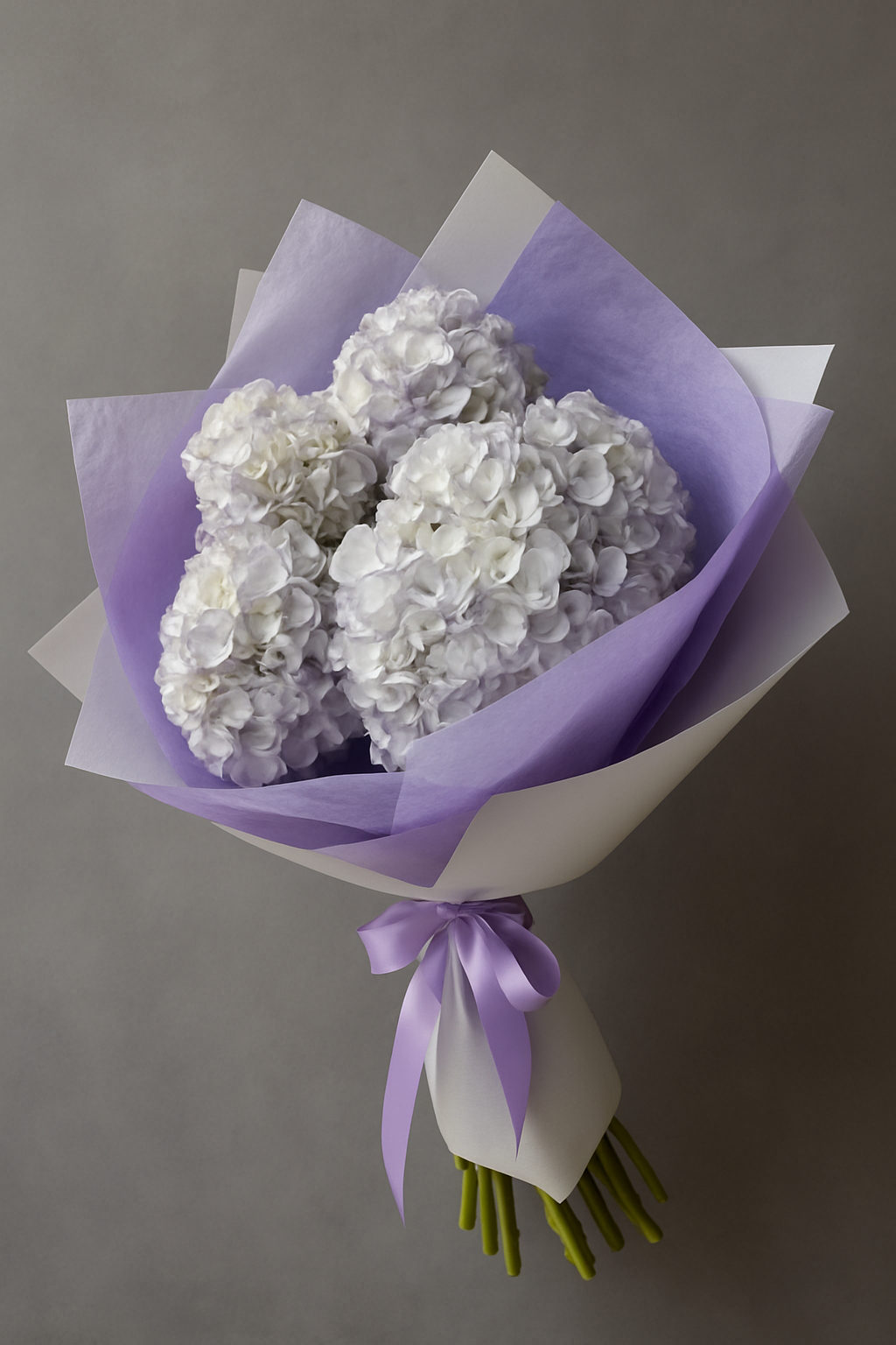 Purple hydrangea bouquet Marbella with white flowers wrapped in purple and white paper tied with a purple ribbon