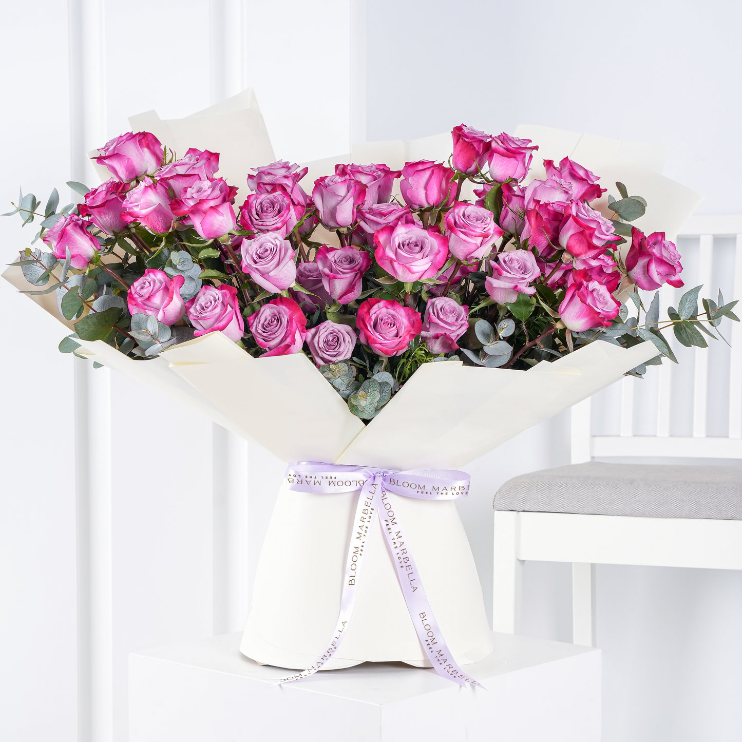 Purple rose bouquet Marbella with pink and lavender roses wrapped in white paper by Bloom Marbella