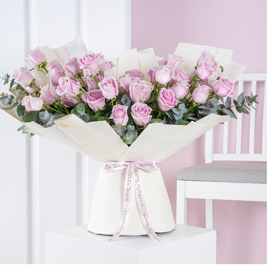 50 pink roses bouquet with eucalyptus leaves wrapped in white paper tied with Bloom Marbella ribbon
