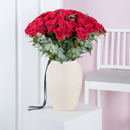 50 red roses in vase arranged with green foliage in a cream ceramic vase from Bloom Marbella