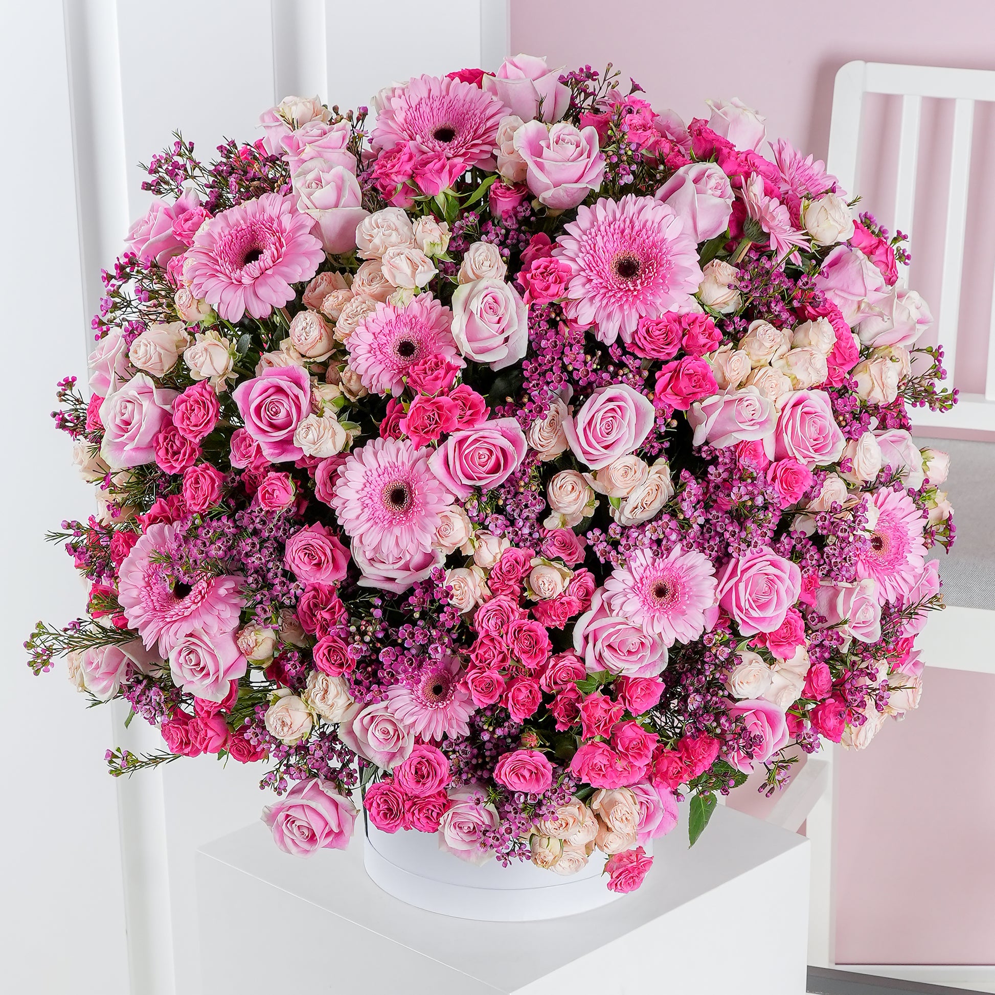 Coraline hatbox flower arrangement by Bloom Marbella featuring pink roses and gerbera daisies in a round white hatbox