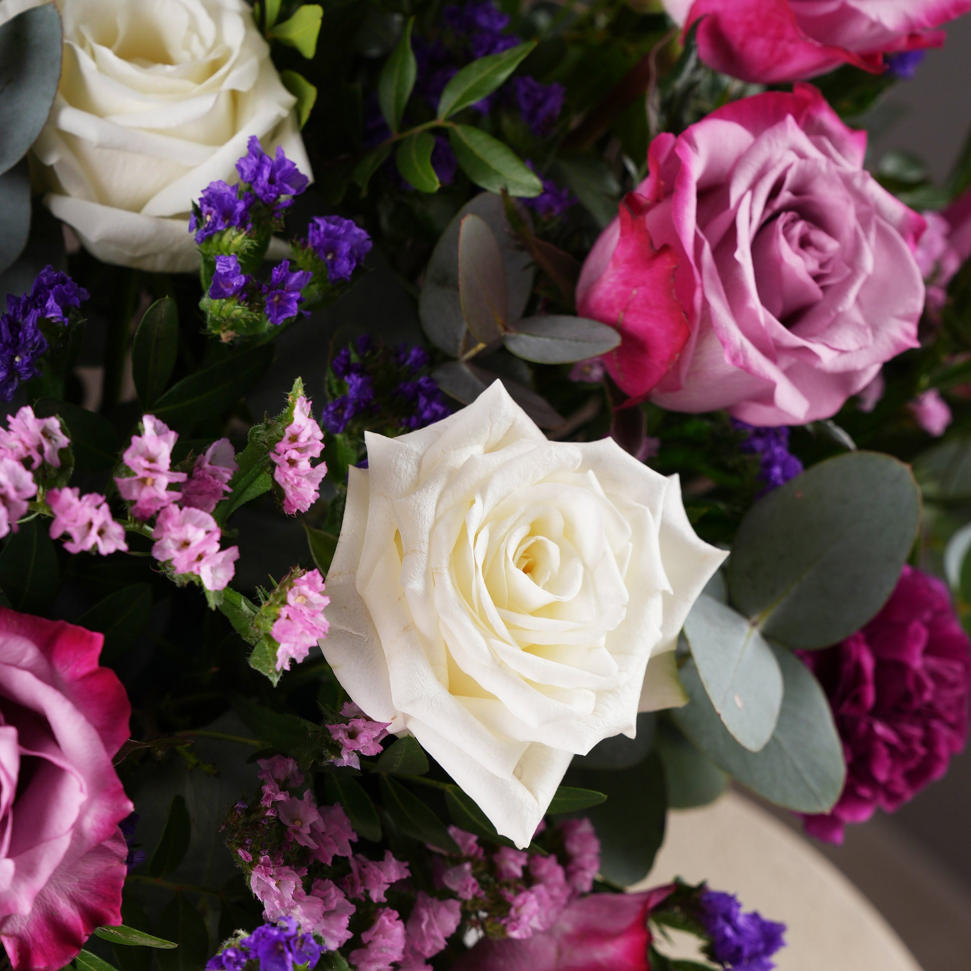 Close-up of lavender hatbox flowers Marbella featuring white and pink roses with purple and pink filler flowers