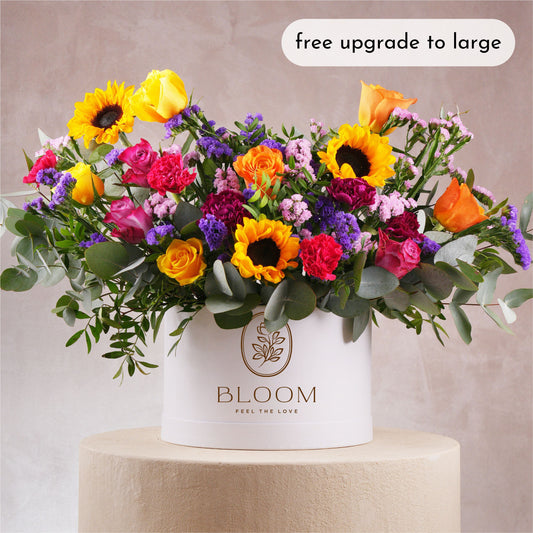 Luxury flower hatbox Marbella by Bloom Marbella with vibrant sunflowers roses and mixed blooms in white round box