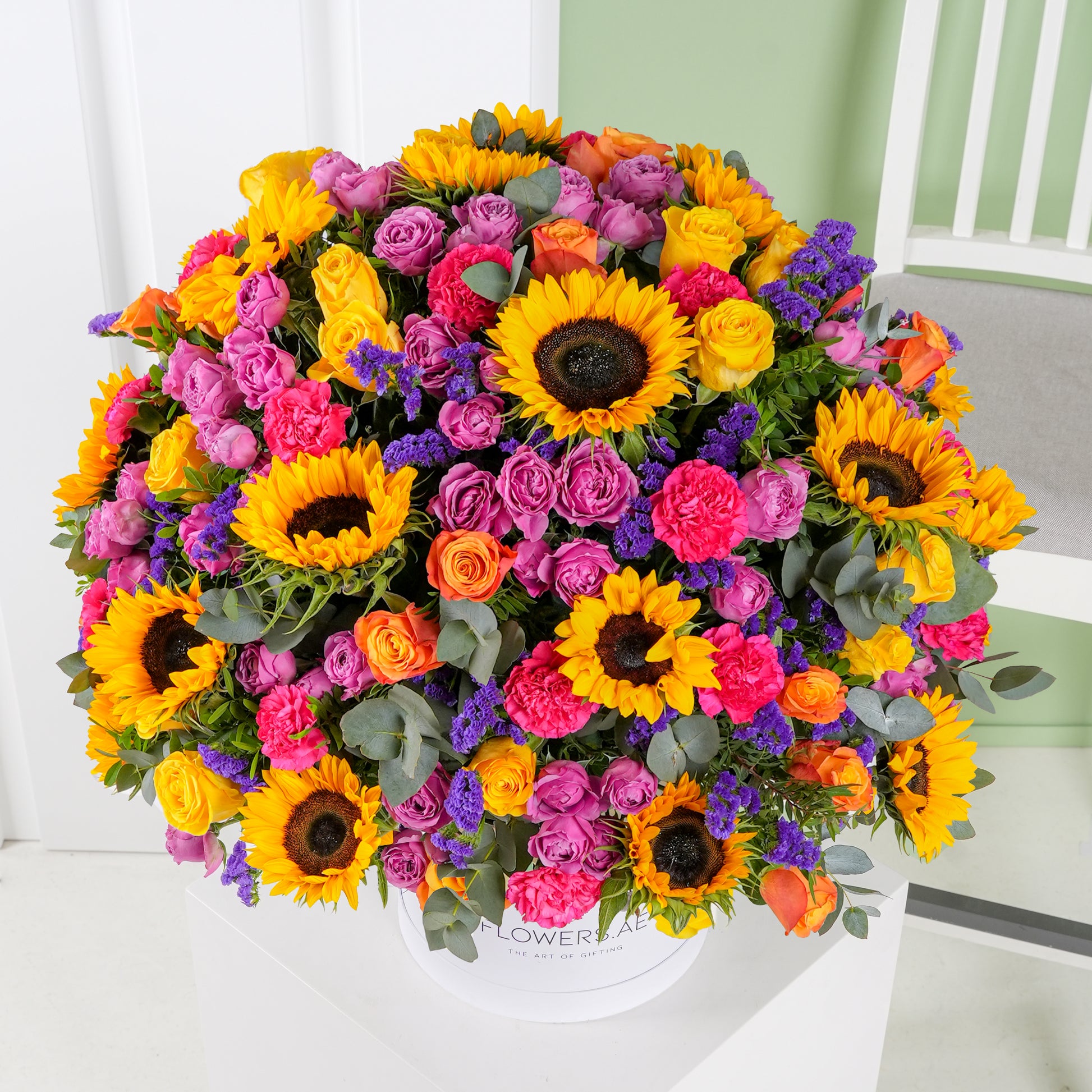 Luxury flower hatbox Marbella with vibrant sunflowers, pink roses, orange roses, and purple flowers by Bloom Marbella