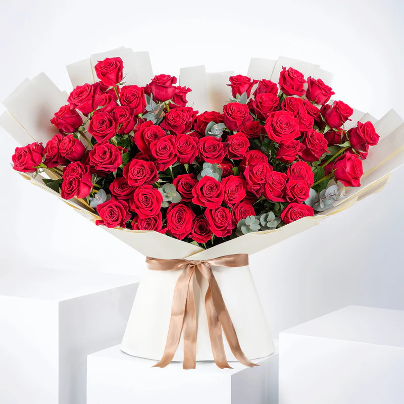 100 red roses bouquet - Bloom Marbella Spain with lush red roses wrapped in white paper and tied with a beige ribbon