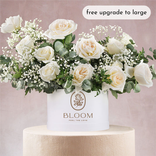 White hatbox flower arrangement Bloom Marbella featuring white roses and greenery in elegant white container