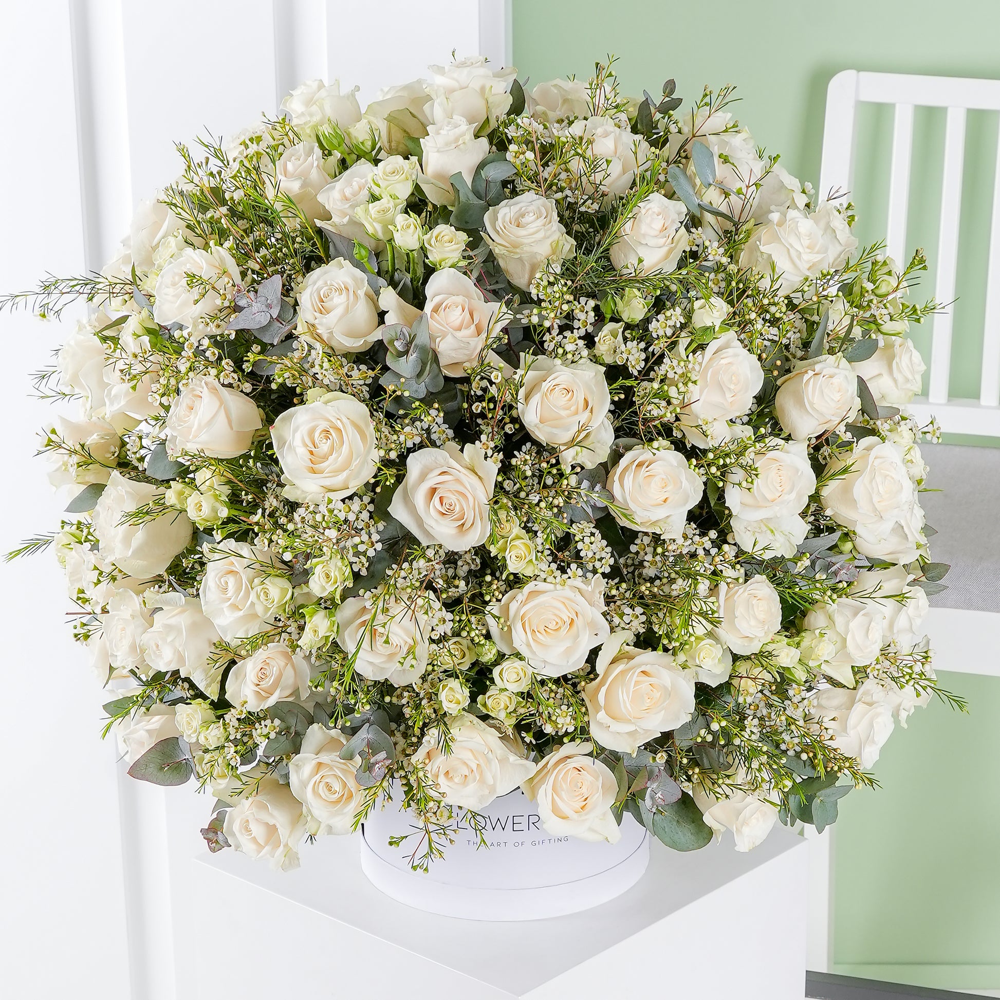 White rose hatbox Marbella arrangement by Bloom Marbella featuring lush white roses and greenery in a round white box