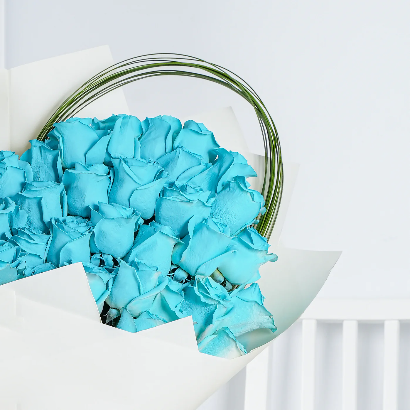 Bloom Marbella blue rose bouquet Marbella wrapped in white paper with decorative green wire