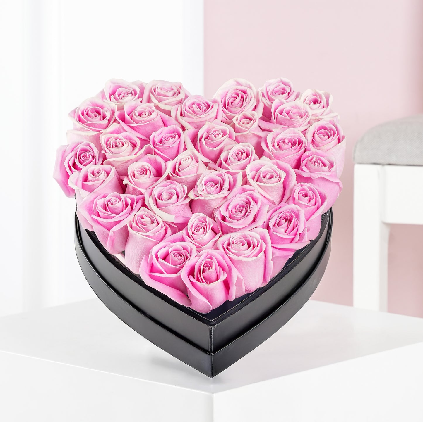 Heart shaped rose arrangement of pink roses in a black box by Bloom Marbella on a white table