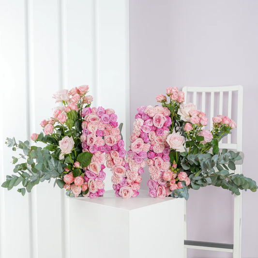 Luxury floral letter arrangement shaped as the letter M with pink roses and green foliage