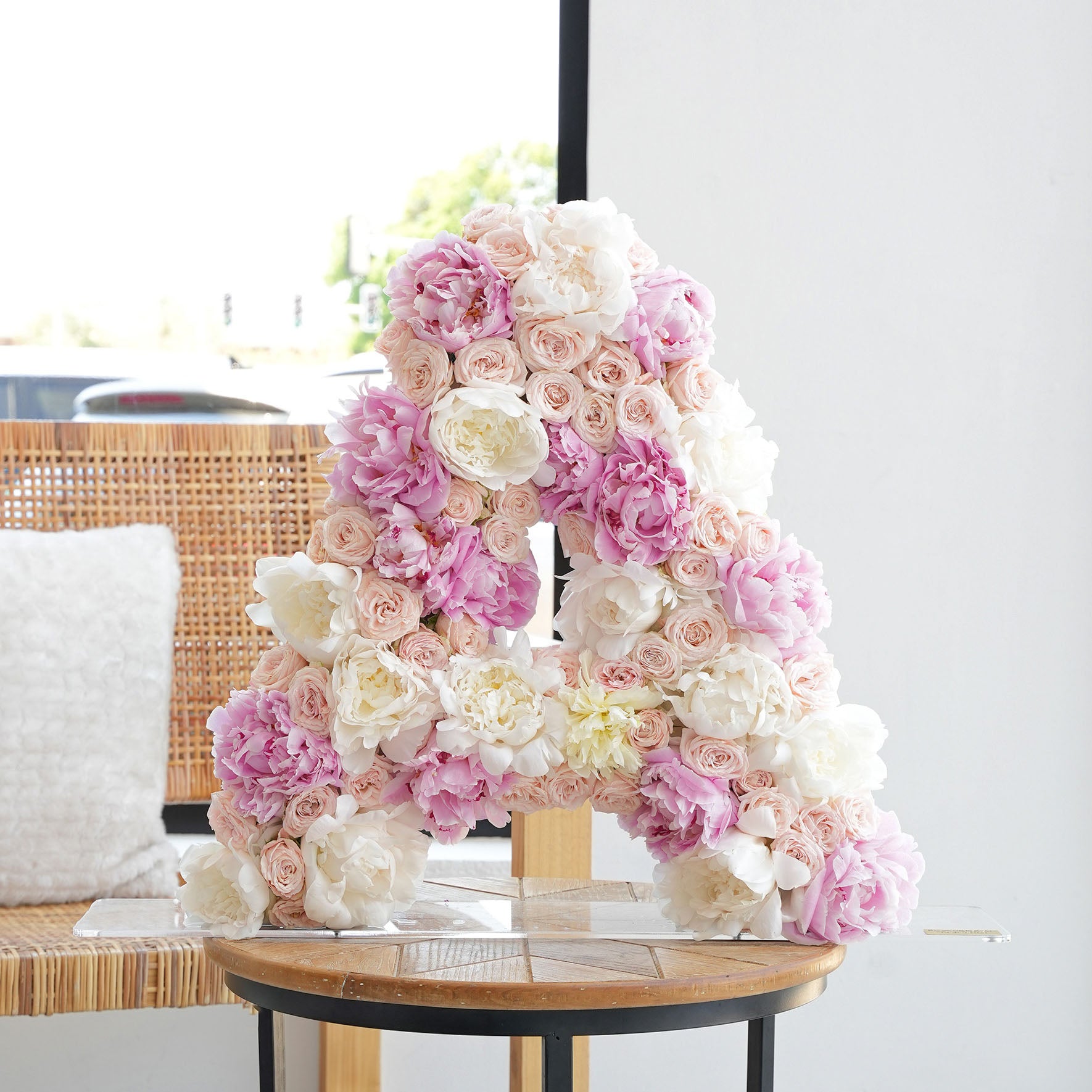 Luxury floral letter arrangement by Bloom Marbella featuring pink and white roses and peonies shaped as the letter A