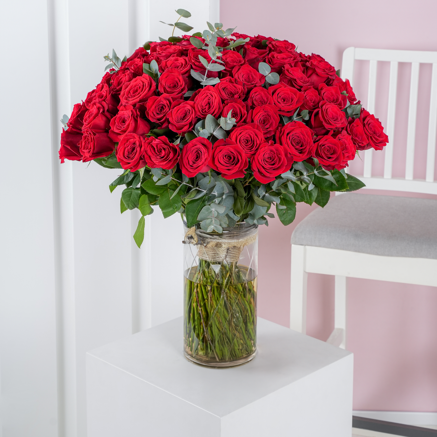 100 red roses bouquet Marbella arranged in a clear glass vase with green foliage by Bloom Marbella
