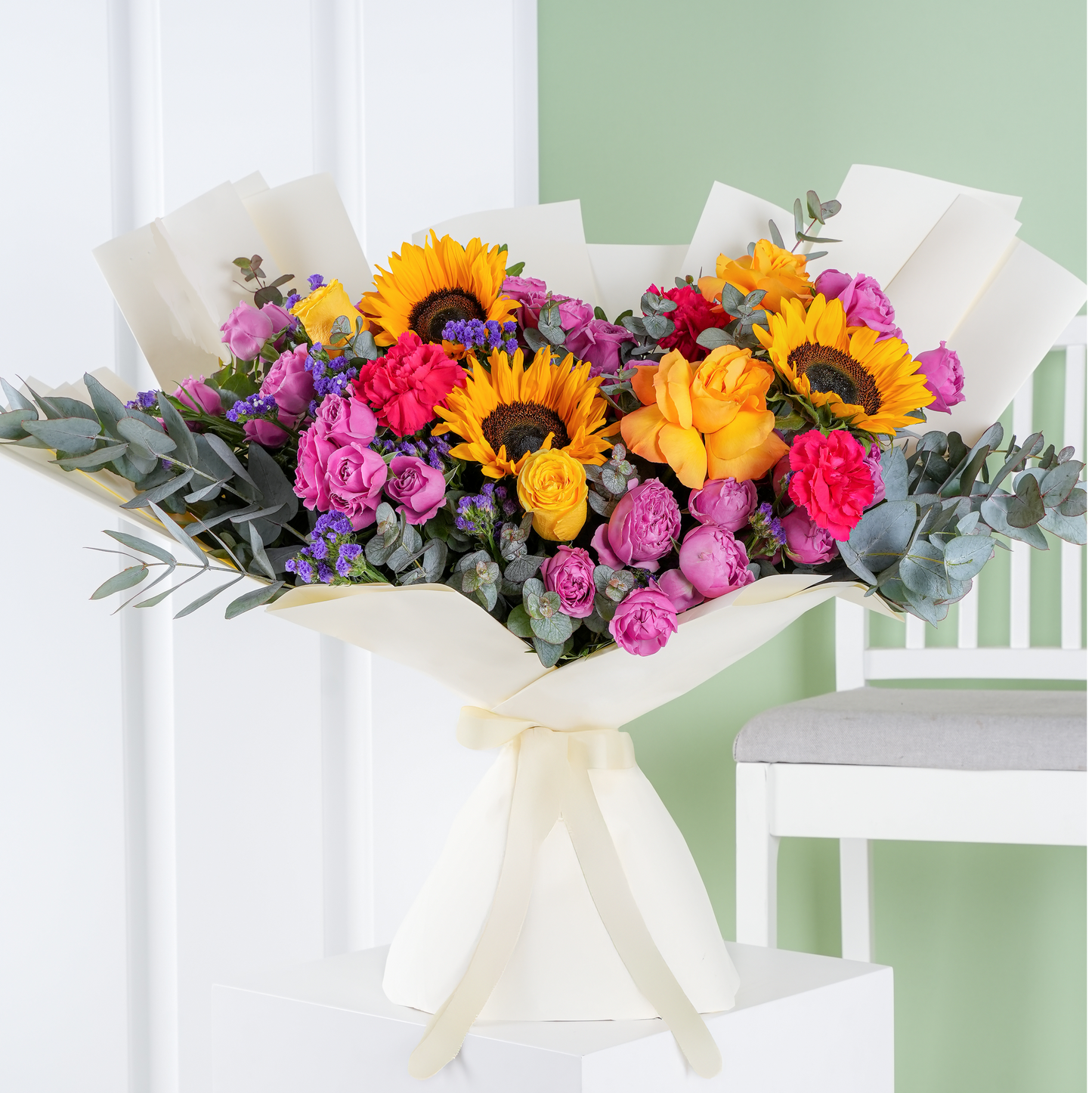Premium colorful floral arrangement vibrant bloom marbella with sunflowers yellow roses and pink flowers wrapped in white paper
