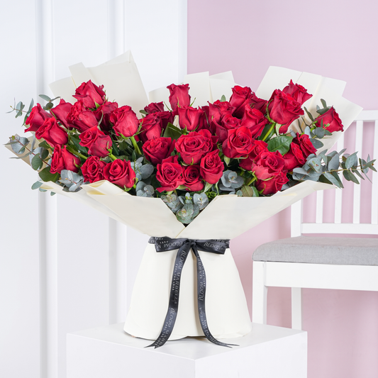 Elegant red rose bouquet Marbella with lush red roses and green eucalyptus wrapped in white paper by Bloom Marbella