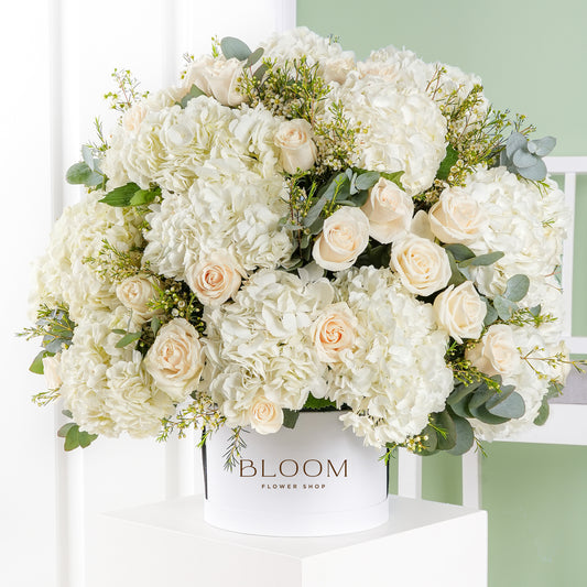 Elegant white hydrangea and cream rose flower arrangement in a Bloom Marbella white box